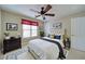 Cozy bedroom featuring a ceiling fan, natural light, and warm, neutral tones at 251 Waterford Cove Dr, Suwanee, GA 30024