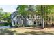 Charming two-story home with a well-manicured lawn and mature trees providing shade and curb appeal at 251 Waterford Cove Dr, Suwanee, GA 30024
