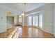 Open-concept living room with hardwood floors, bay windows, and traditional chandelier at 251 Waterford Cove Dr, Suwanee, GA 30024