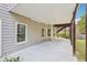 A covered patio with concrete flooring and natural wood support beams at 2064 Democracy Dr, Buford, GA 30519