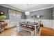 Formal dining room with a modern chandelier, wainscoting, hardwood floors, and gray walls at 2064 Democracy Dr, Buford, GA 30519