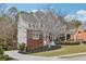 View of home showing brick and gray siding, well manicured lawn, and deck leading from driveway at 2064 Democracy Dr, Buford, GA 30519