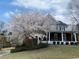 Inviting home with a classic porch, mature trees, and well-kept landscaping, creating a welcoming curb appeal at 2064 Democracy Dr, Buford, GA 30519