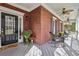 Inviting covered front porch with brick facade, ceiling fans, and comfortable seating at 2064 Democracy Dr, Buford, GA 30519