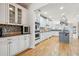 A spacious kitchen featuring white cabinets, hardwood floors, stainless steel appliances, and granite countertops at 2064 Democracy Dr, Buford, GA 30519