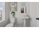 Bathroom with white fixtures, a framed painting, a mirror and blind-covered window at 399 Skylar Se Way, Atlanta, GA 30315