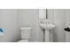 Powder room with pedestal sink and white toilet at 399 Skylar Se Way, Atlanta, GA 30315