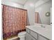 Bathroom featuring stylish vanity with grey cabinets and white countertop paired with a toilet and patterned shower curtain at 399 Skylar Se Way, Atlanta, GA 30315