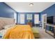 Bedroom featuring blue walls, carpet, large windows, and a bed with a tufted headboard at 399 Skylar Se Way, Atlanta, GA 30315