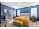 Bedroom featuring blue walls, carpet, and a bed with floral patterned sheets and tufted headboard at 399 Skylar Se Way, Atlanta, GA 30315