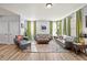 Open-concept living room with gray couches, wood floors, bright green curtains, and lots of natural light at 399 Skylar Se Way, Atlanta, GA 30315