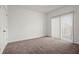 Spacious bedroom with neutral carpet, white walls, and a large window with vertical blinds at 525 Parkway Dr Ne # 203, Atlanta, GA 30354