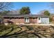 The back of the home is highlighted by a brick exterior, complemented by a concrete patio and green space at 1523 Vancouver Dr, Tucker, GA 30084