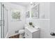 Bright bathroom featuring white tile, modern vanity, stylish fixtures, and glass shower doors at 1523 Vancouver Dr, Tucker, GA 30084