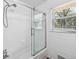 Bright tiled bathroom featuring glass shower doors and large, sunlit window at 1523 Vancouver Dr, Tucker, GA 30084