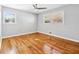 Bright bedroom featuring wood floors, two windows, and a ceiling fan at 1523 Vancouver Dr, Tucker, GA 30084