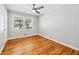 Neutral bedroom offering a ceiling fan, window, and classic wood floors at 1523 Vancouver Dr, Tucker, GA 30084