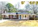 Charming brick home with a well-manicured lawn, front porch, and blue front door at 1523 Vancouver Dr, Tucker, GA 30084