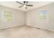 Cozy bedroom featuring neutral walls, carpet flooring, two windows and a ceiling fan at 2302 Abner Nw Pl, Atlanta, GA 30318