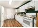 Kitchen featuring white cabinets, wood-look floors, a gas range, and stainless steel appliances at 2302 Abner Nw Pl, Atlanta, GA 30318