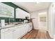 Cozy kitchen with dark green accent wall, white cabinets, and wood-look flooring at 2302 Abner Nw Pl, Atlanta, GA 30318