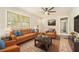 Bright living room with wood floors, an orange sofa, an orange armchair, and a ceiling fan at 2302 Abner Nw Pl, Atlanta, GA 30318