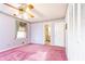 Carpeted bedroom featuring fan, curtained window, and closet; doorway leads to bathroom at 7278 Selkirk Dr, Atlanta, GA 30328