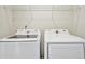 Modern laundry room featuring a Samsung washer and dryer with a wire rack above at 2240 Mulsanne Dr, Lithonia, GA 30058