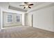 Spacious carpeted main bedroom featuring a tray ceiling and neutral walls at 2240 Mulsanne Dr, Lithonia, GA 30058