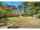 Expansive fenced backyard with a grassy lawn, mature trees, and a storage shed at 3385 Lyndale St, Douglasville, GA 30135