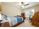 Bedroom with neutral carpet, ceiling fan, dresser and bed near a window and desk at 8220 Majors Ridge Way, Cumming, GA 30041