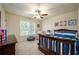 Cozy bedroom with ceiling fan, large window, and bed with blue and white striped comforter at 8220 Majors Ridge Way, Cumming, GA 30041