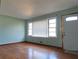 Living room with light blue walls, hardwood floors, door, and a bright window at 1879 Mural Cir, Morrow, GA 30260