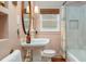 Charming bathroom with pink walls, pedestal sink, an oval mirror, a shower curtain and wood floors at 306 Nelms Ne Ave, Atlanta, GA 30307