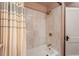 Bathroom tub and shower featuring neutral colored shower curtain and white textured wall tiles at 306 Nelms Ne Ave, Atlanta, GA 30307