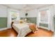 Bright bedroom with green wainscoting, hardwood floors, large windows with white curtains, and a hanging plant at 306 Nelms Ne Ave, Atlanta, GA 30307