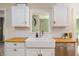 Close up of a white farmhouse style sink with stainless dishwasher and wood counters at 306 Nelms Ne Ave, Atlanta, GA 30307