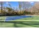 Full-size tennis court on a partially cloudy day for recreation and exercise, with a fenced border in a green setting at 306 Nelms Ne Ave, Atlanta, GA 30307