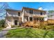 Rear view of home features a large deck and a well-manicured lawn, enhancing outdoor living at 565 Ashvale Overlook, Alpharetta, GA 30005