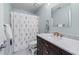 Well-lit bathroom featuring a stylish vanity, marble countertop, and shower with a floral curtain at 565 Ashvale Overlook, Alpharetta, GA 30005