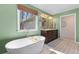 Beautiful bathroom featuring a freestanding tub, double vanity, and a bright window at 565 Ashvale Overlook, Alpharetta, GA 30005