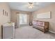 Charming Bedroom with soft colors, featuring a crib, changing table, and window with natural light at 565 Ashvale Overlook, Alpharetta, GA 30005