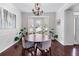 Charming dining room with a chandelier, wainscoting, large windows, and a round wooden table at 565 Ashvale Overlook, Alpharetta, GA 30005