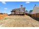 Backyard view featuring a deck, covered patio, privacy fence and tidy landscaping for outdoor enjoyment at 6951 Foxmoor Way, Douglasville, GA 30134