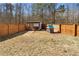 A fenced backyard features a playhouse and storage shed offering a safe and fun space for children at 6951 Foxmoor Way, Douglasville, GA 30134