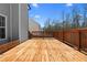 A large, stained wooden deck with railing offers outdoor living space, great for entertaining and relaxing at 6951 Foxmoor Way, Douglasville, GA 30134