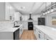 A kitchen features white cabinets, stainless steel appliances, black fixtures, and a large center island with a white marble countertop at 6951 Foxmoor Way, Douglasville, GA 30134