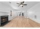 Living room showcases wood-look flooring, a ceiling fan, and a fireplace with views to the kitchen at 6951 Foxmoor Way, Douglasville, GA 30134