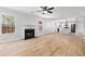 Living room showcases wood-look flooring, a ceiling fan, and a fireplace with views to the kitchen at 6951 Foxmoor Way, Douglasville, GA 30134