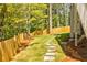 A peaceful backyard featuring a stone pathway through the grass and lush green trees at 783 Phil Haven Ln, Kennesaw, GA 30152